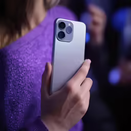 a person holding a samsung note 20 silver
