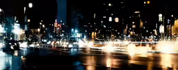 a night view of a street with cars and buildings with lights at night