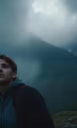 a man stands on the edge of a mountain while looking away from the camera
