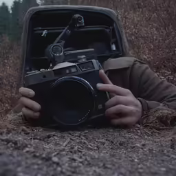a man laying on the ground holding a camera