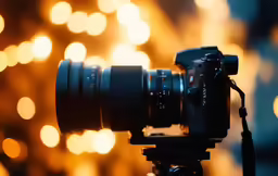 a video camera attached to a tripod with many lights behind it