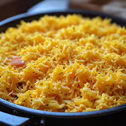 a close up shot of grated cheese on the inside of a pan