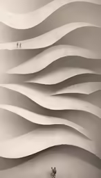 two people standing near a white wall made from sand dunes
