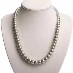 a white pearl necklace on a mannequin head