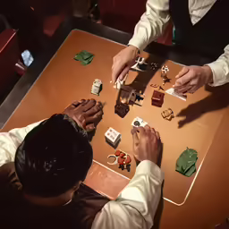 two people playing domino card game on table