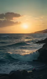 the sun sets over some ocean waves with rocky shoreline