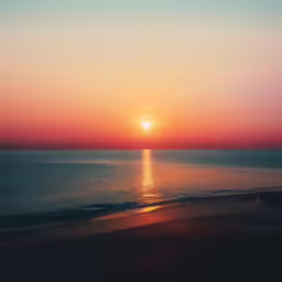 a picture of the sun setting in the ocean