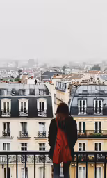 the girl in black jacket is looking out over the city
