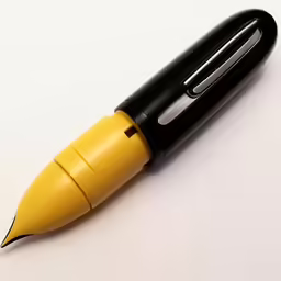 a yellow and black ball pen is sitting on a white table
