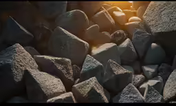 the sun is setting over rocks in the water