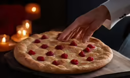 a person cutting up a pie with raspberries