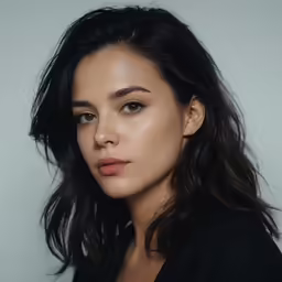 the model is looking straight ahead, with her hair flying in the wind