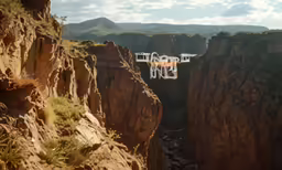 a person riding a plane over a canyon