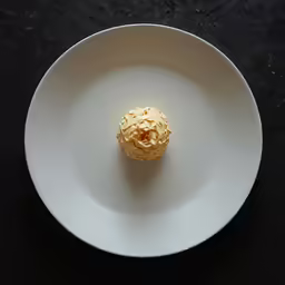 a white plate topped with a dessert covered in yellow icing