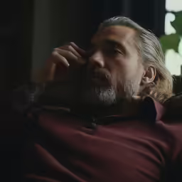 a man with tattoos is sitting on the couch