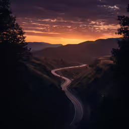 a winding road stretches between the mountains into the distance