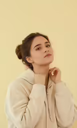 a woman wearing a white coat posing for the camera
