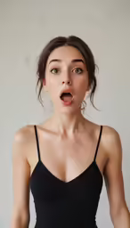 young woman making surprised face and wearing a short black dress