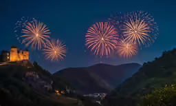 large colorful fireworks above a castle on a hill
