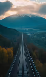 a train track with a view of mountains and clouds