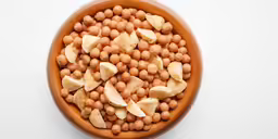 a wooden bowl filled with beans, banana slices and sliced bananas