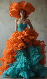 a woman with a large multi - colored dress and a huge hat
