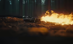 an old fashioned car near a fire in the woods