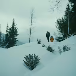 two people standing on top of a snow covered hill
