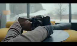 man taking photos with his camera in front of a couch