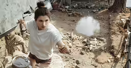 a woman in the dirt pulling something around with her hand