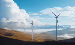 several wind turbines in a field under a blue sky