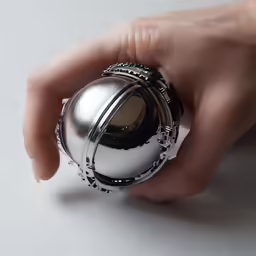 a person is holding a metal object with their hand