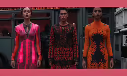 three models stand on a runway at a fashion show
