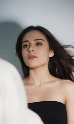 the woman is wearing a black strapless top