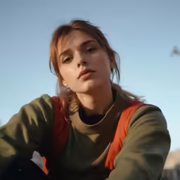 a woman posing with her arms crossed in a blue sky