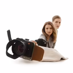 two people are laying on the ground with a camera