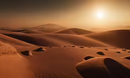 sand dunes and mountains with sun setting