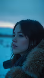 young woman with big fur collar staring away