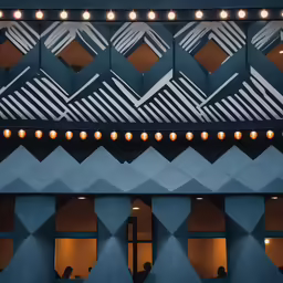 people looking at a light installation on top of a building