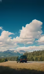a blue truck driving down the side of a highway