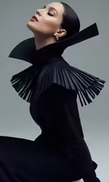 a woman in black is posing in a dress