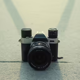 a camera and some empty cups sitting on the ground