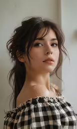 a woman in a checkered top with long hair
