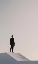 a man standing on the top of a small, steep slope