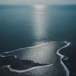 the ocean and land are seen from a high above