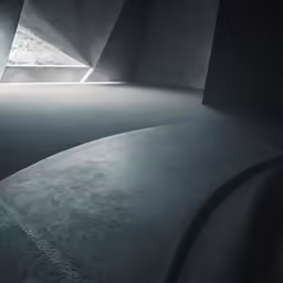 the corner of a concrete room with sunlight beaming through