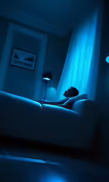 woman laying on a couch in the dark with blue light on her