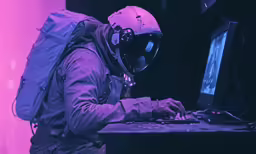 a man wearing a gas mask working on his laptop