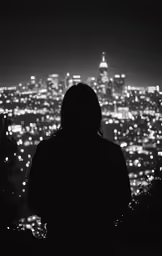 a woman standing in front of a city at night