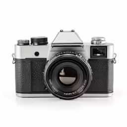 a silver and black camera on a white surface